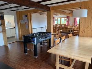 a room with a ping pong table and a dining room at Modernes Skihaus auf der Wolzenalp 33Betten in Nesslau