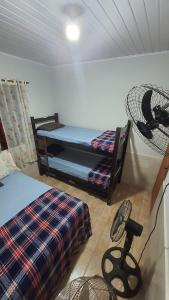 a bedroom with two bunk beds and a fan at Casa de temporada do Mr Bim in Cabo Frio +45 photos