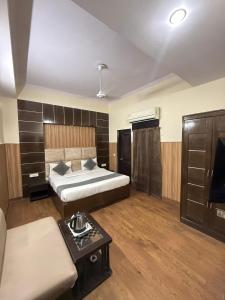 ニューデリーにあるHOTEL S HOSPITALITY - Karol Bagh Metro & Ganga Ram Hospitalのベッドルーム1室(ベッド2台、ソファ、テーブル付)