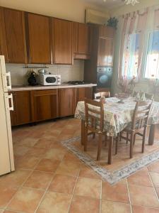 a kitchen with a table with chairs and a microwave at Bianca Marea in Realmonte