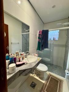 a bathroom with a sink and a toilet and a shower at Casa Para Hóspedes em Peruíbe - SP in Peruíbe