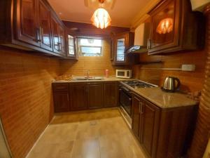 a small kitchen with wooden cabinets and a sink at Luxury furnished apartment for rent - شقة فاخرة مفروشة للإيجار in Amman