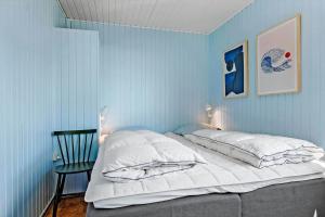 Un dormitorio azul con una cama y una silla. en 3664-Nexo-Strandvolden-11, en Neksø