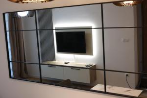 a mirror hanging on a wall with a tv on it at Stan na dan Sneguljica in Sarajevo