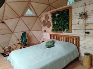 a bedroom with a bed in a wooden room at Les Dômes de Draëck in Zutkerque