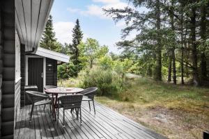 a wooden deck with a table and chairs on it at 1444-Aakirkeby-Poseregardsvejen-15 in Vester Sømarken