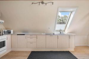 a kitchen with a sink and a window at 5613-Allinge-Bohnebakken-21-Lejl-1 in Allinge +11 photos
