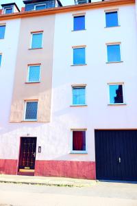 ein weißes Gebäude mit zwei Eingängen und zwei Garagentoren in der Unterkunft Holiday Rhein5 in Boppard