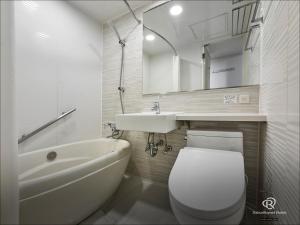 a white bathroom with a toilet and a sink at Daiwa Roynet Utsunomiya in Utsunomiya