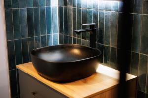 a black sink on a wooden counter in a bathroom at "Badestube Loft" im Zentrum von Bad Hersfeld mit modernem Design und offenem Wohnkonzept in Bad Hersfeld