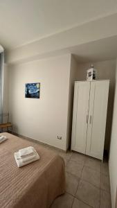a bedroom with a bed and a white cabinet at La Lanterna Apartment in Canicattì