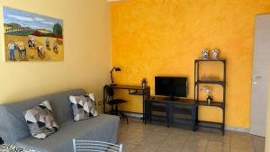 a living room with a couch and a desk with a television at La Lanterna Apartment in Canicattì
