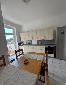 a kitchen with a wooden table and a refrigerator at Seibel's SUITES - Big in Essen - Family & Group in Essen