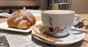 a cup of coffee and a pastry on a table at La Maison Fleurie in San Nicola Arcella +11 photos