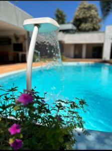 a water fountain in front of a swimming pool at Quinta La Calma in Puerto Iguazú