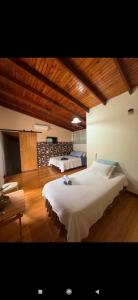 a bedroom with two beds and a wooden floor at Quinta La Calma in Puerto Iguazú