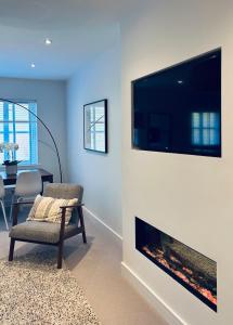 a living room with a fireplace with a tv on a wall at Luxury 2 bedroom flat Gleneagles in Moffat +13 photos