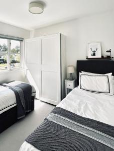 a white bedroom with two beds and a window at Luxury 2 bedroom flat Gleneagles in Moffat