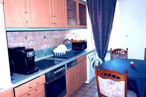 a kitchen with a stove top oven next to a table at Holiday Rhein 3 in Boppard