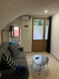 a living room with a couch and a table and a door at Studio cosy in Bourg-Saint-Andéol +5 photos