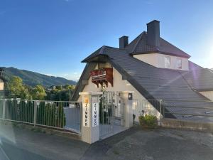 a house with a black roof and a fence at Liesingtal Deluxe Balcony Suite in Liesingthal +9 photos