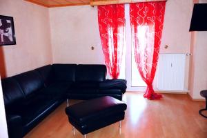 a living room with a black couch and red curtains at Holiday Rhein 4 in Boppard