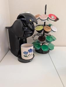 a coffee pot and cups on top of a table at Warm and cozy apartment in Tromsø, free parking and near both airport, city and nature in Tromsø +23 photos