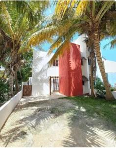 a building with palm trees in front of it at 1 Minute Walk to the Beach! in Telchac Puerto