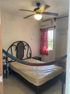 a bed in a room with a ceiling fan at 1 Minute Walk to the Beach! in Telchac Puerto +25 photos