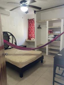 a room with a bed with a rope around it at 1 Minute Walk to the Beach! in Telchac Puerto