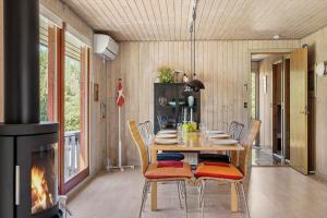 a dining room with a table and a fireplace at LF16181-Logstor-Abelonesvej-19 in Løgsted