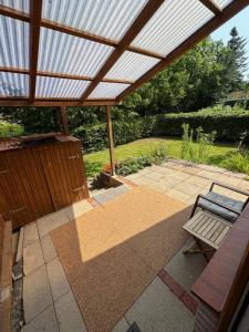 a patio with a wooden pergola and a bench at Terrassenwohnung im Alstertal in Hamburg