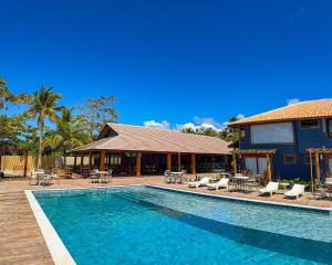 a swimming pool in front of a house at Hotel Espelho D'Água Arraial e Beach Club in Arraial d'Ajuda