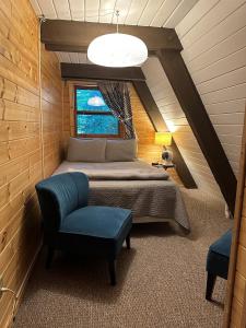 a bedroom with a bed and a chair in a attic at Rocky Pines UP in Bessemer