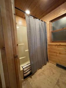 a bathroom with a shower with a shower curtain at Rocky Pines UP in Bessemer