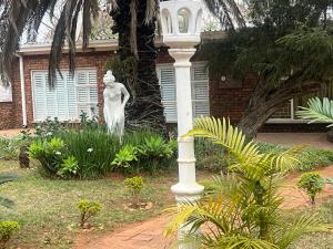 a statue of a woman in front of a house at Mooka in Pyramid