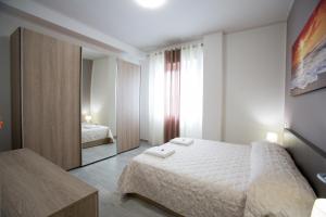 チヴィタノーヴァ・マルケにあるLa Suiteのベッドルーム(白いベッド1台、鏡付)