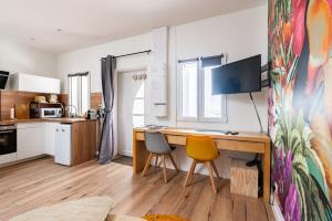 ディジョンにあるCozy studio with wooden terrace and private Jacuzziの机と椅子2脚、コンピューターを備えたキッチン +24枚の写真