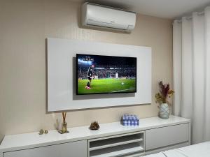 einen TV an der Wand mit einem Fußballspiel darauf in der Unterkunft Apartamento suíte com estacionamento in Porto Alegre