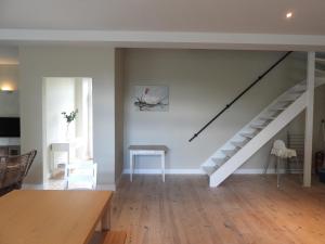 a living room with a staircase and a table at Ô lit de l'Ourthe in Hotton