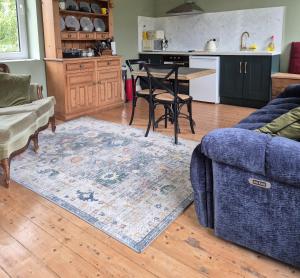 a living room with a blue couch and a kitchen at Apartment-Sleeps2-Parking-Garden-Patio in Castleisland +12 photos