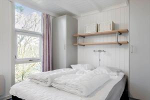 una camera da letto con un letto con lenzuola bianche e una finestra di LF634-Vestervig-Gunhildsvej-54 a Vestervig Altre 21 foto