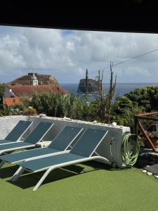 a group of blue lounge chairs sitting on the grass at Villa Matilde e Joaquim in Porto da Cruz