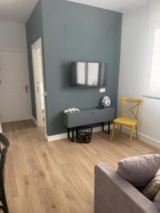 Alojamientos Dima Costa في لاريدو: غرفة معيشة مع أريكة وكرسي أصفر