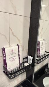 a bathroom mirror with two products on a shelf at 1BR, Living Room, Olaya in Al Khobar