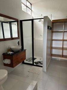 a bathroom with a shower and a sink and a toilet at casa del sol in Tena +5 photos