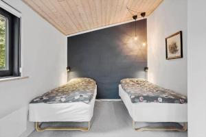 two beds in a small room with a blue wall at LF15210-Hojslev-Jelsevej-210 in Højslev