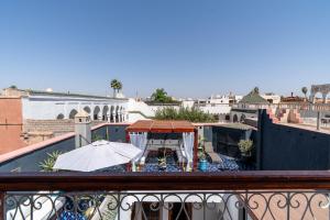 a balcony with a table and an umbrella at Riad Serendip in Marrakesh