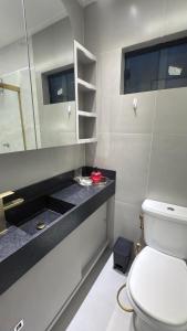 a bathroom with a white toilet and a sink at Flat magnífico bairro nobre in Imperatriz