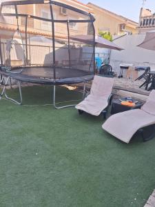 a patio with two chairs and a bird cage at House Heart in Amora
